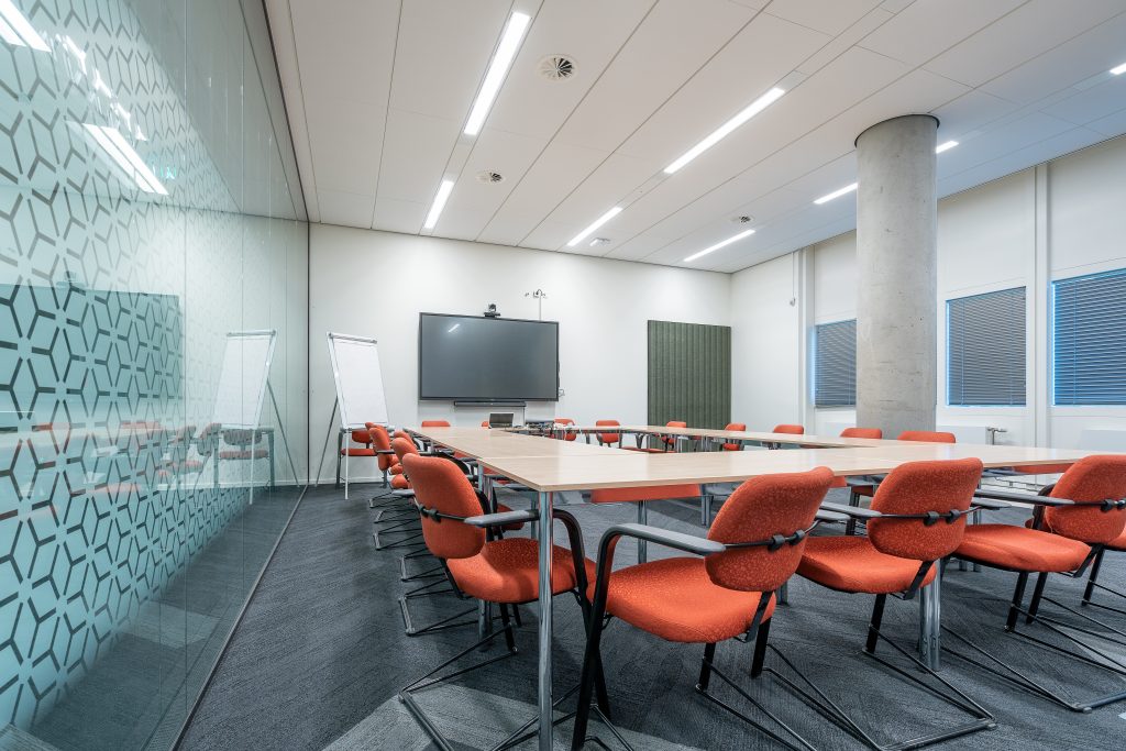 Ein großer Konferenraum der mit Präsentation und Medientechnik ausgestattet ist